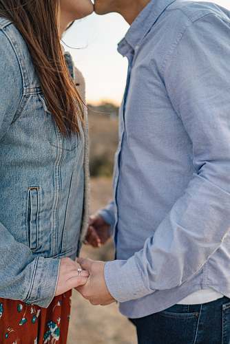 human man and woman kissing while holding hands holding hands