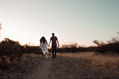 human man and woman near road holding hands