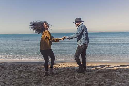 human man and woman standing on seashore apparel