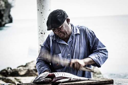 people man cutting raw fish using knife human