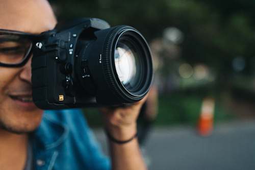 human man holding black DSLR camera camera