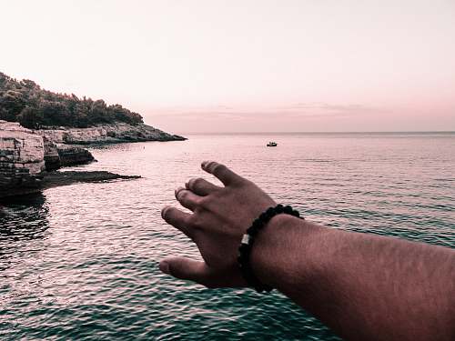 human man wearing black beaded bracelet hand