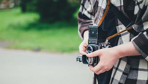 human person carrying DSLR camera in shallow focus photography camera