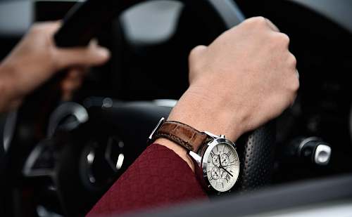 watch person driving car with black steering wheel wrist watch