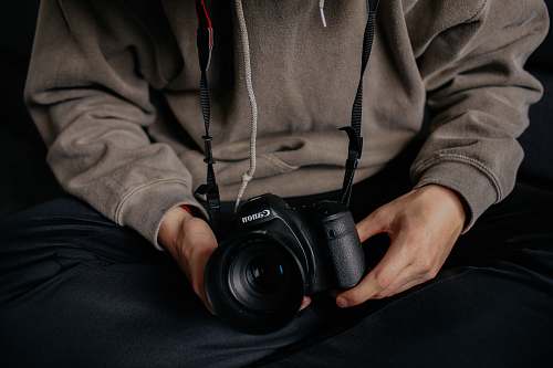 people person holding black Canon DSLR human