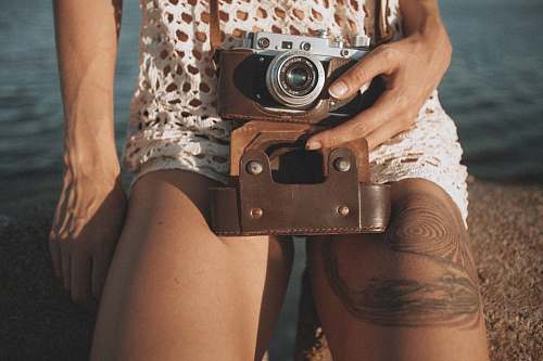 human person holding camera near water camera