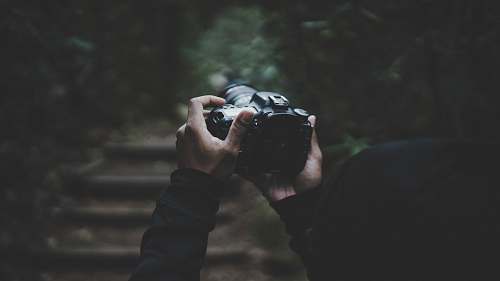 human person holding DSLR camera people