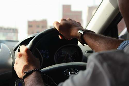human person holding steering wheel hand