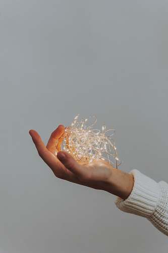 human person holding string lights finger