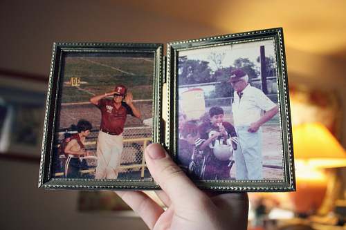 people person holding two father and son photographs human