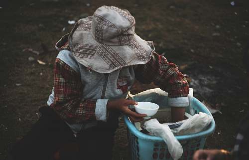 people person in hat holding bowl while hand inside basket human