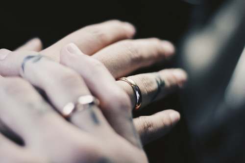 human person showing two gold-colored rings hand
