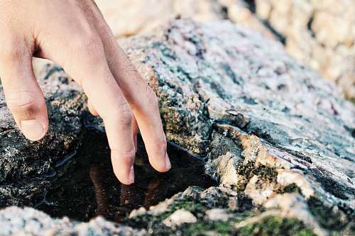 human person touching water rock