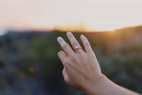 human person wearing gold-colored ring finger