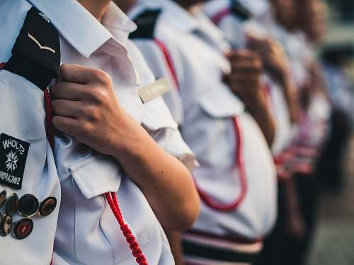 human person wearing officer uniform putting his closed arms on his left chest at daytime singapore