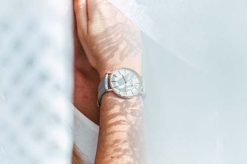wristwatch person wearing round white analog watch hand
