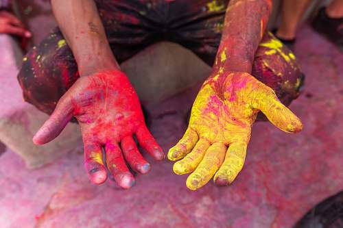 human person's hand with yellow and red powder hand