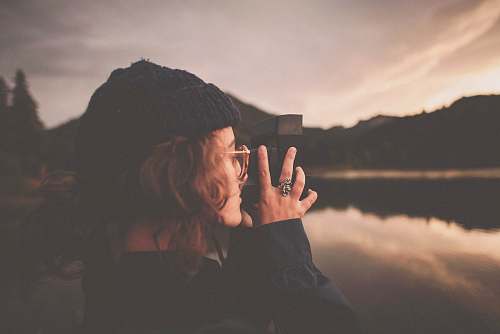 human photograph of woman taking a picture of body of water people