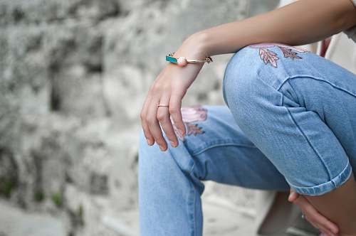 jeans shallow focus photography of woman sitting on stair denim