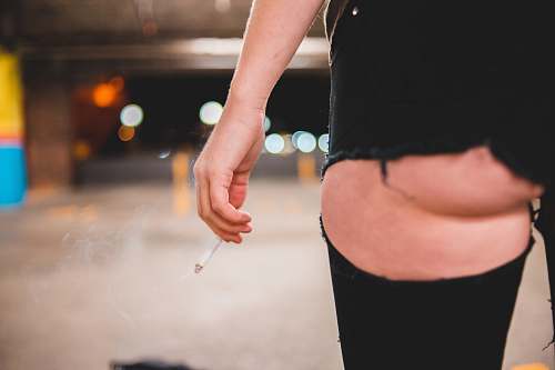 human woman in black shorts inside a lighted parking lot hand