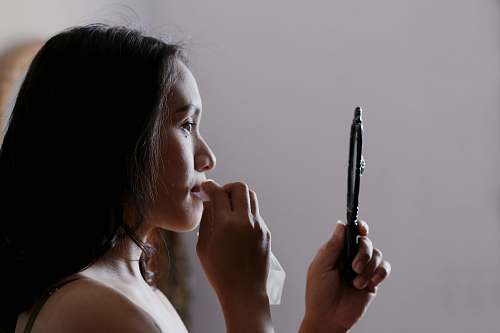 people woman looking to mirror and wiping her lips human