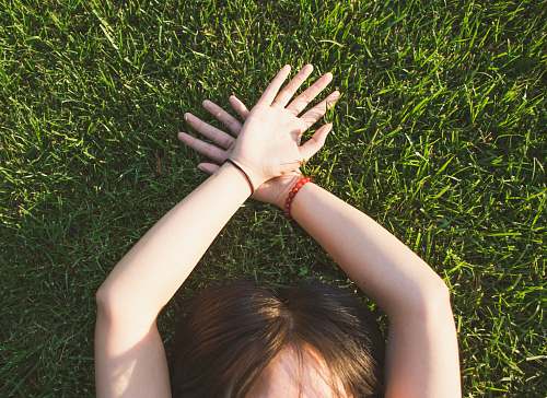 human woman lying on green grass grass