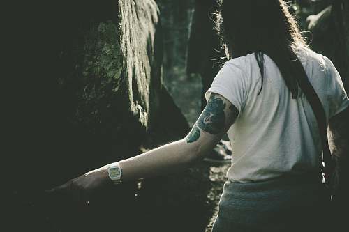 human woman standing in front of tree tattoo