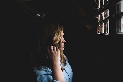 human woman touching her hair while looking at the window inside house girl