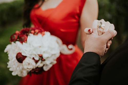 wedding woman wearing red scoop-neck sleeveless dress holding white flower boquet flower