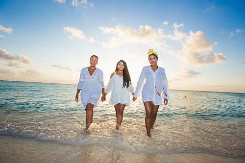 ocean three women holding hands in seashore beach