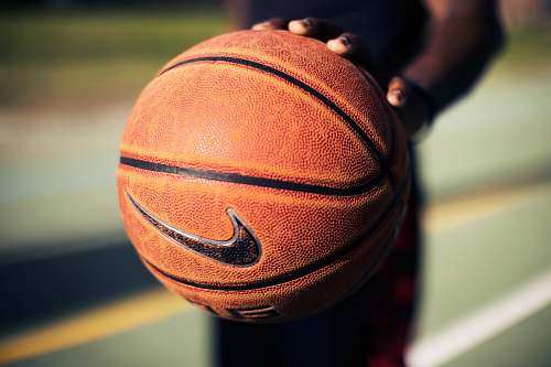 basketball person holding brown Nike basketball nike