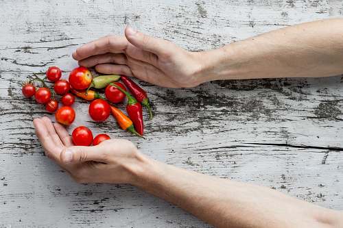 vegetable person hand's about to get cherry tomatoes and bell peppers food