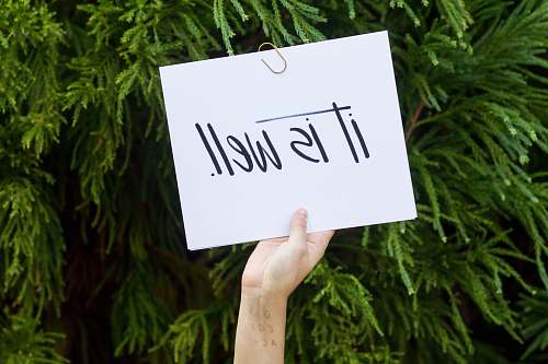 sign person holding white paper with it is well text message
