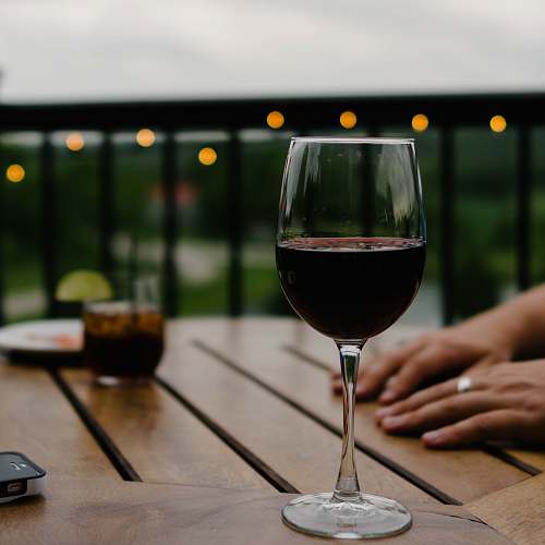 glass person hand on top of a table drink