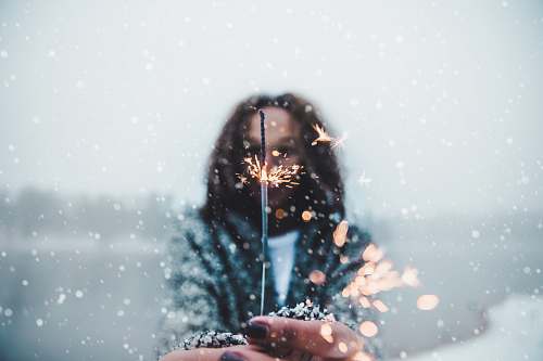 snow woman holding sparkler bokeh light nature
