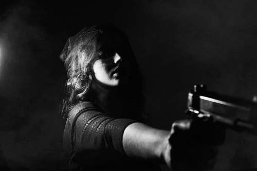 black-and-white woman holding pistol weapon