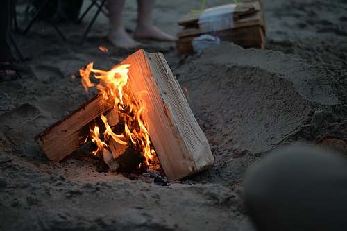 bonfire campfire on sand near person campfire