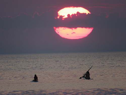 flame person riding on boat under gray sky during daytime la barceloneta