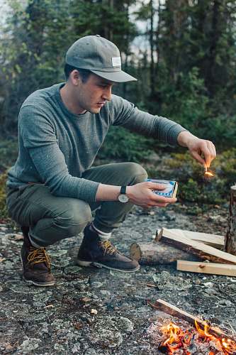 human selective focus photography of man holding lit matchstick outdoors people