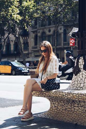 accessory woman in sunglasses sitting on concrete post sunglasses