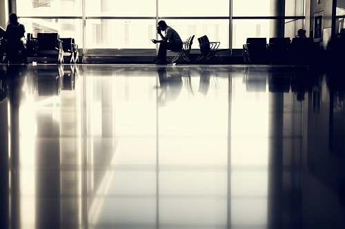 reflection man sitting on chair near glass window man