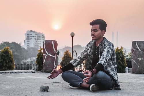 human man sitting on concrete ground person