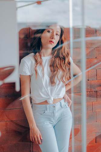 clothing woman standing leaning on brick wall brick