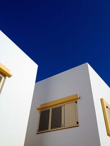 building low angle photography of brown louver window blue