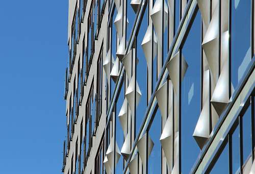 building low-angle photography of curtain wall building under blue sky at daytime facade