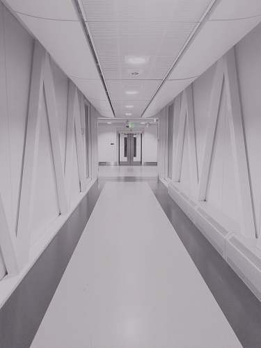 grey person taking photo of white and gray hallway corridor