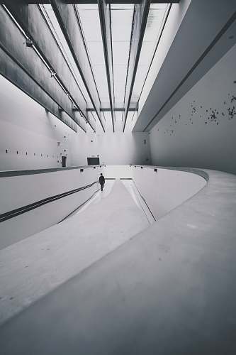 grey person walking beside wall lines