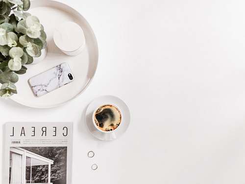 pottery coffee on saucer near white smartphone porcelain