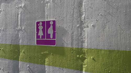 tarmac purple woman and pregnant woman signage on white painted wall wall