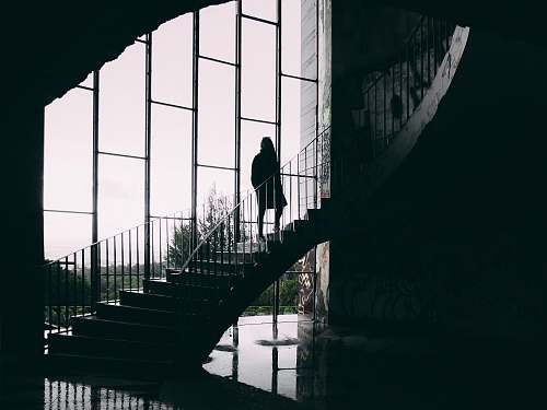 handrail grayscale photography of woman on stair railing